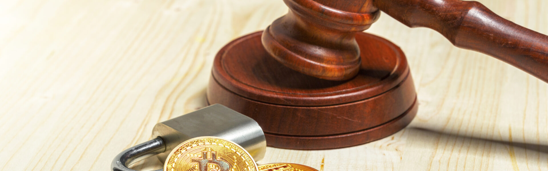 A gavel next to golden Bitcoin coins, symbolizing the U.S. Department of Justice’s decision to dismantle its crypto enforcement unit after a Trump executive order.
