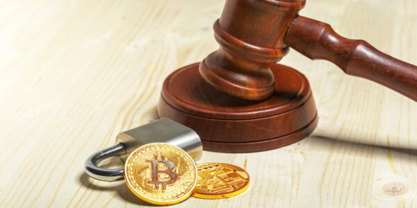 A gavel next to golden Bitcoin coins, symbolizing the U.S. Department of Justice’s decision to dismantle its crypto enforcement unit after a Trump executive order.