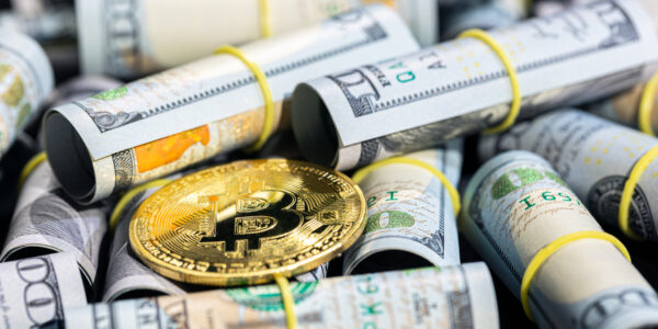Bitcoin placed on rolled U.S. dollar bills, symbolizing the shifting financial landscape as crypto gains traction amid global tariff policies.