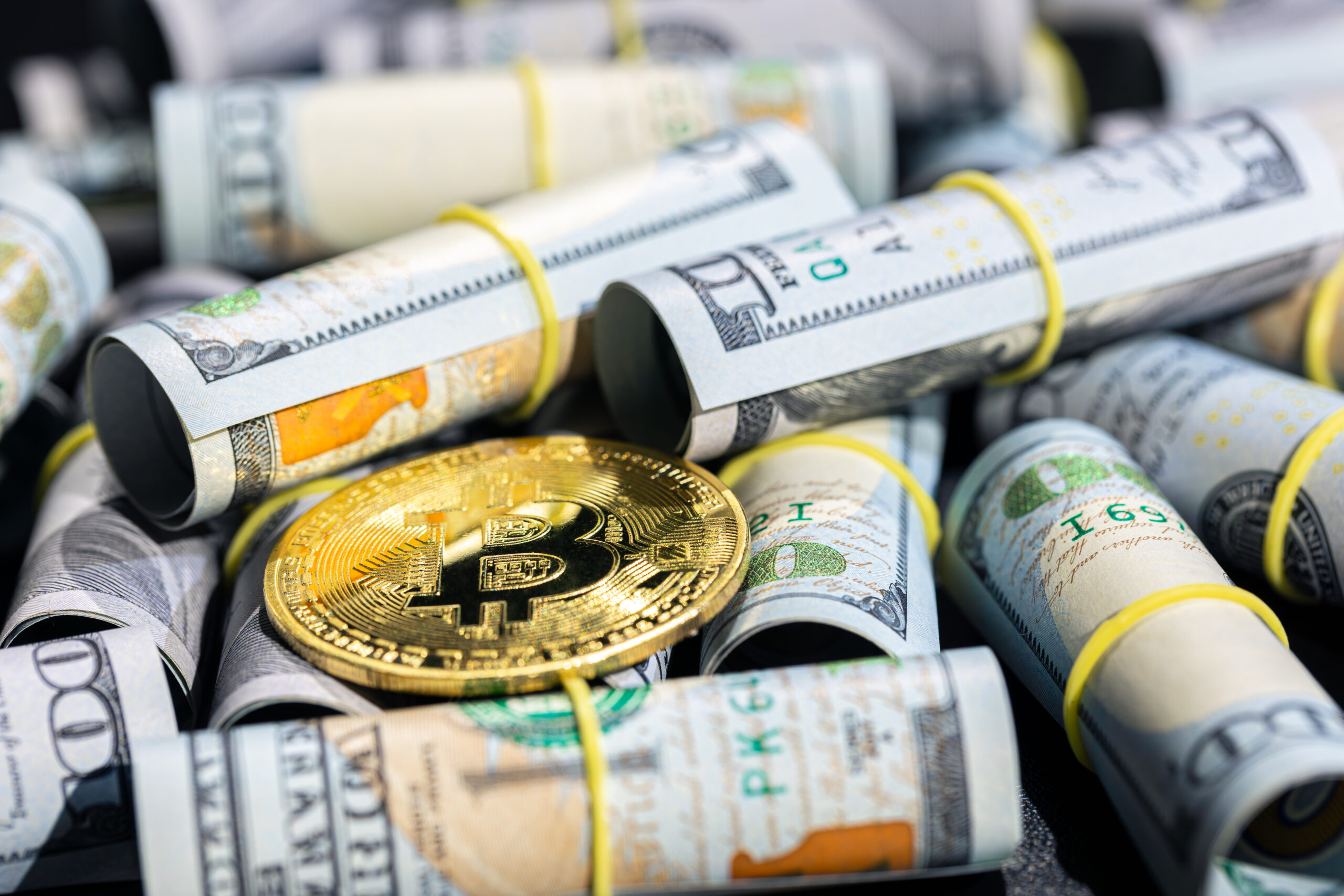 Bitcoin placed on rolled U.S. dollar bills, symbolizing the shifting financial landscape as crypto gains traction amid global tariff policies.