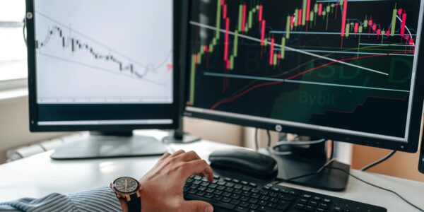 Multiple monitors showing technical analysis charts with sharp trendlines, suggesting a possible breakout in XRP.