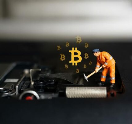 Miniature figure placing a glowing Bitcoin on a computer motherboard, representing Arizona’s growing support for digital mining rights.